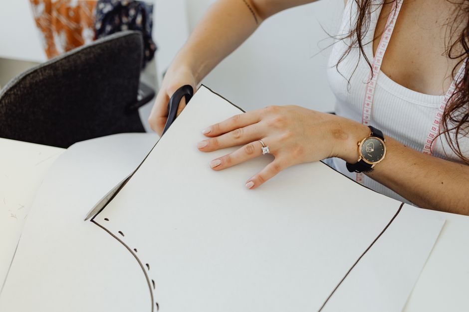 Woman cutting sewing pattern with scissors, embodying creativity and craftsmanship.